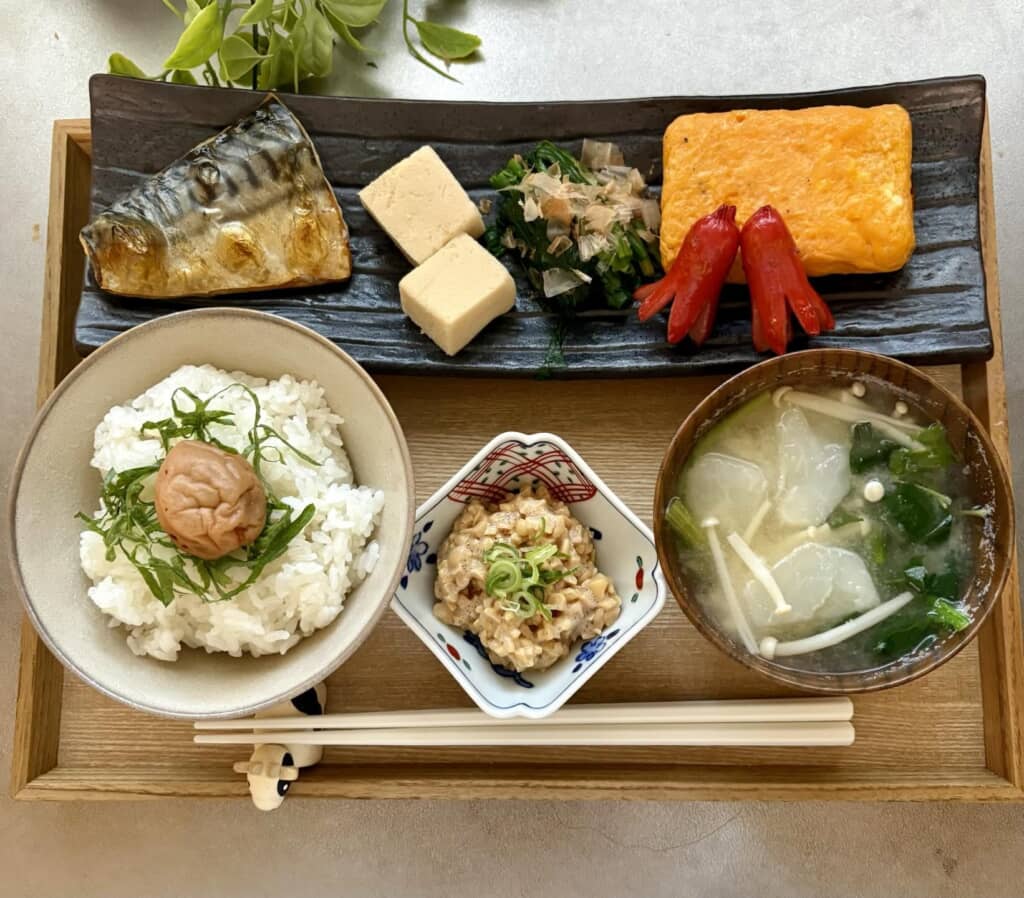 和朝食の定食。焼き魚、だし巻き卵、ご飯と味噌汁が並ぶ食卓