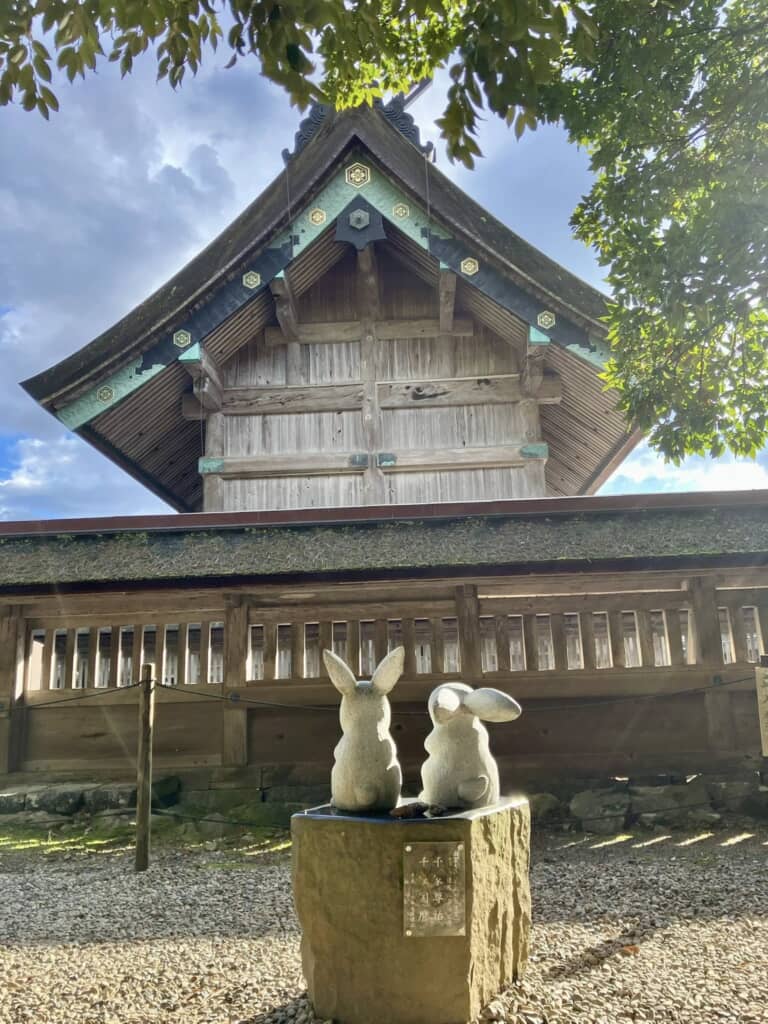 神社の前に並ぶ二体のうさぎ石像と木造社殿