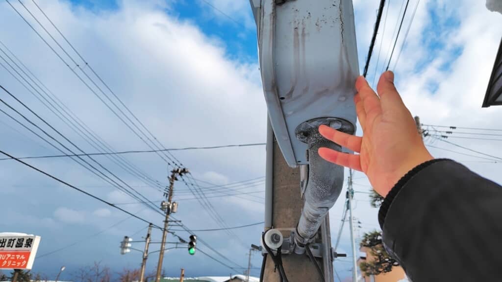雪が分厚く積もったため歩行者用信号機にも触れられる