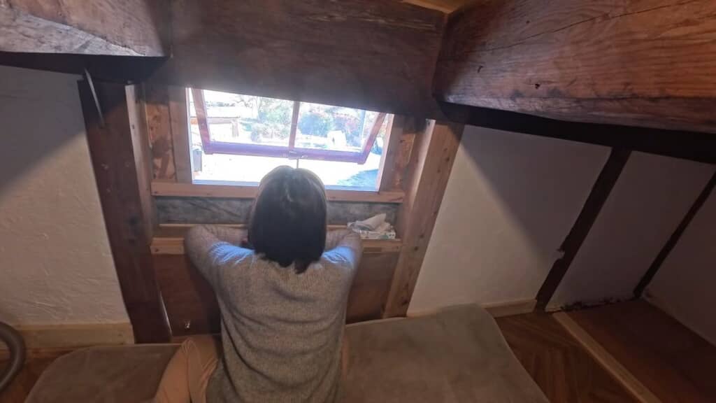 屋根裏部屋の小窓から外を眺める様子