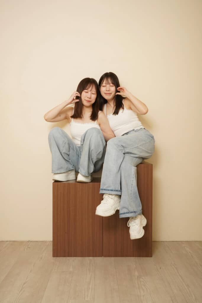 30歳写真、目を閉じてほっぺたをつまむポーズの姉妹