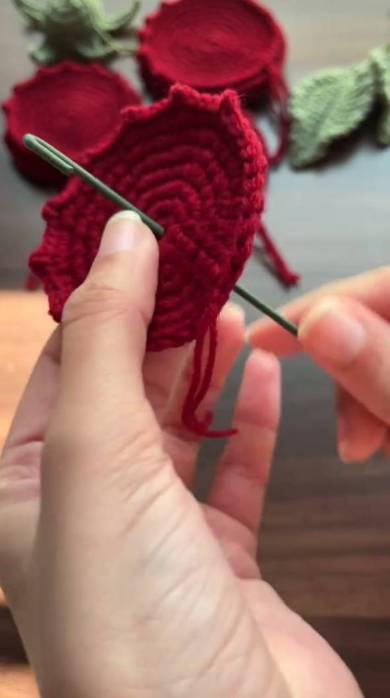 円周がギザギザしている編み物モチーフの中央に緑の棒を通します