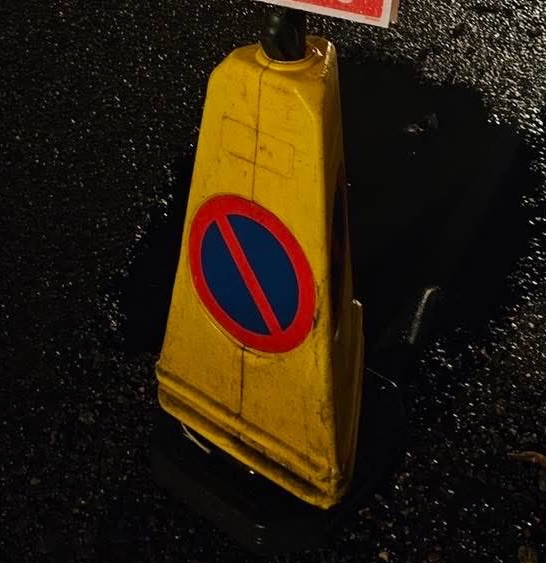 水たまりになった道路の穴のそばにロードコーン