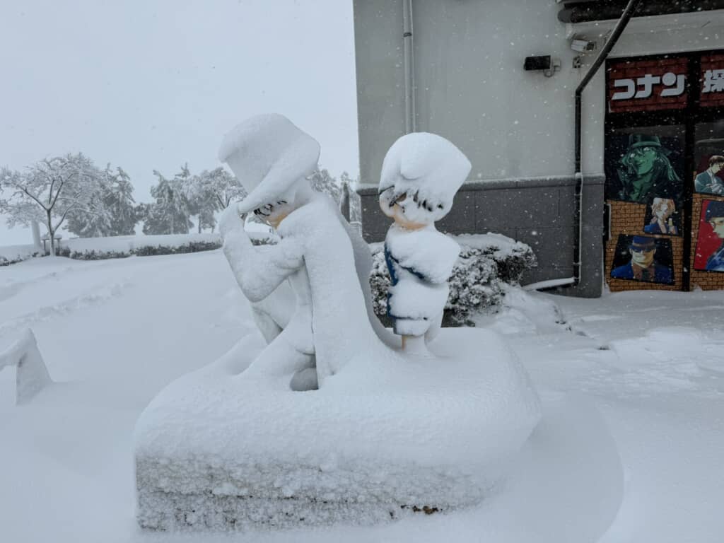 店先のコナン像が雪に覆われる