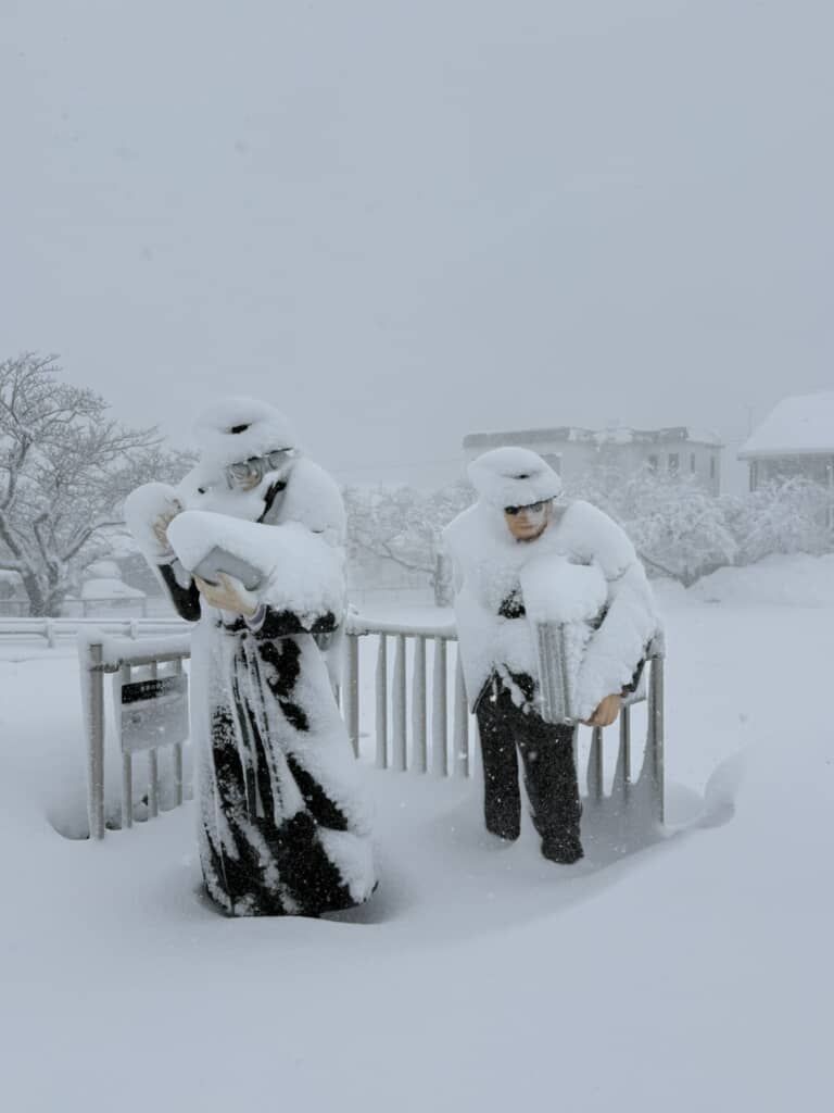 雪に埋もれた男性像