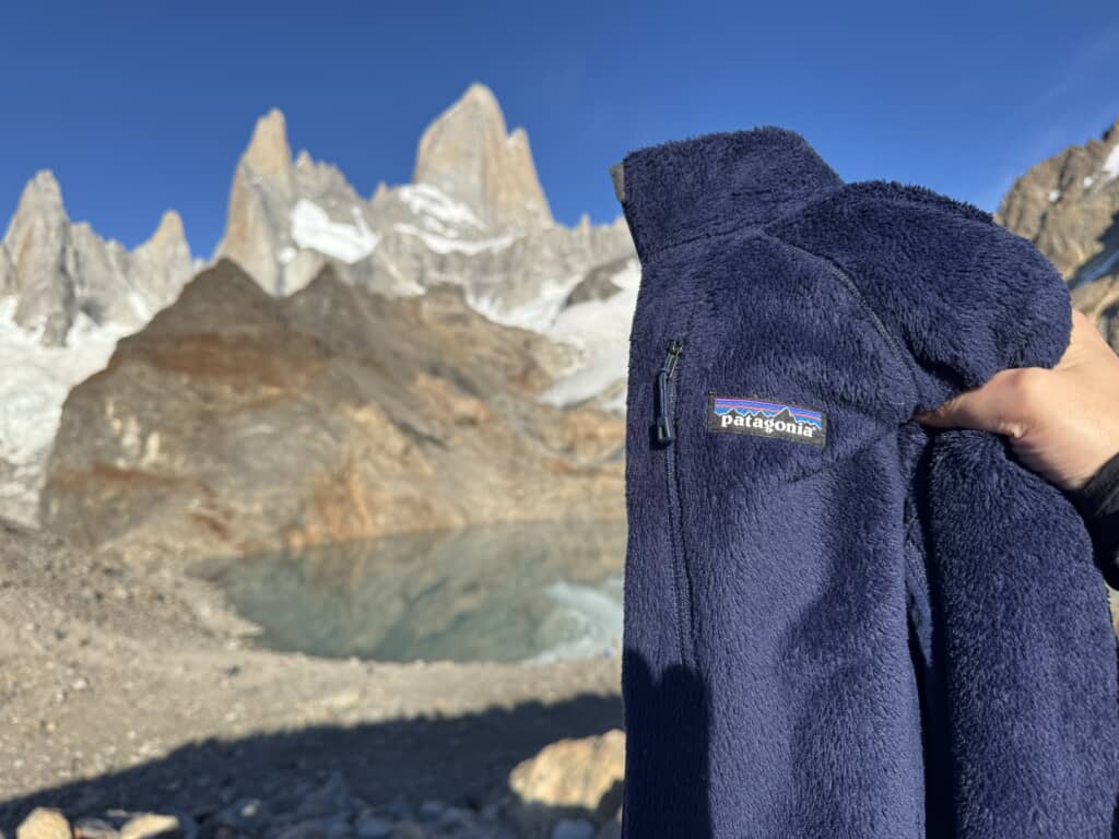 パタゴニアのロゴ入りフリース越しに望むフィッツ・ロイ山と湖の風景