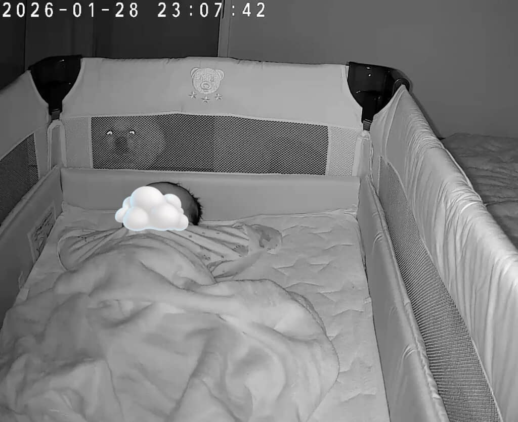 眠る赤ちゃんの背後には……