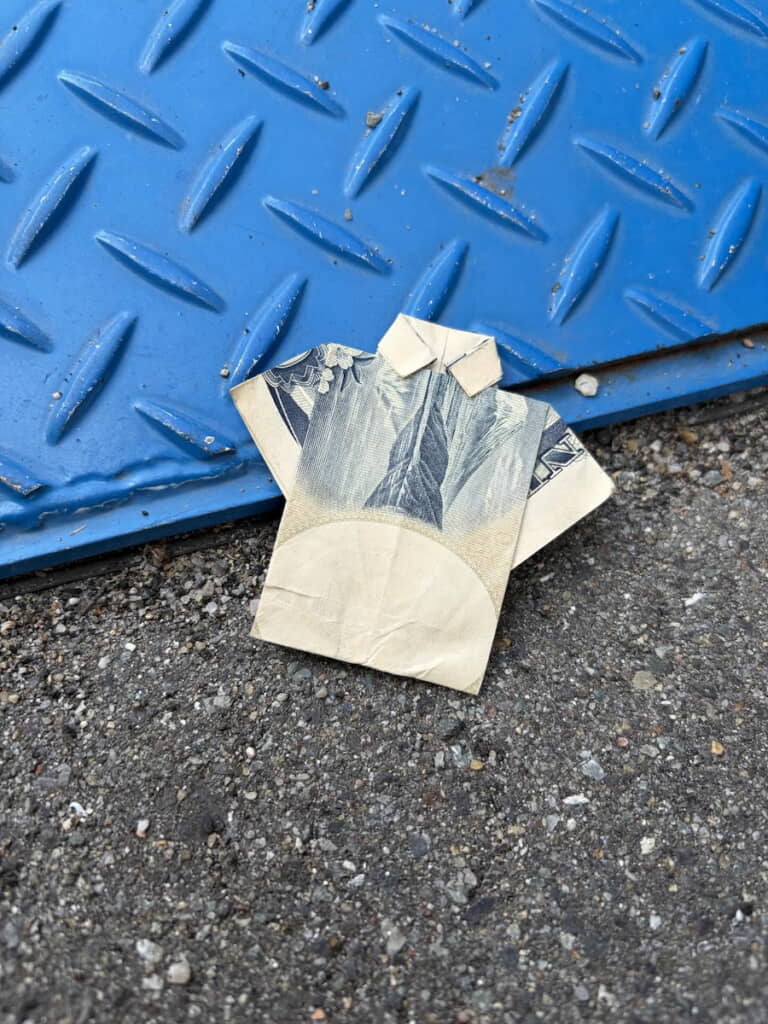 落ちていた1000円札がワイシャツの形に折られている
