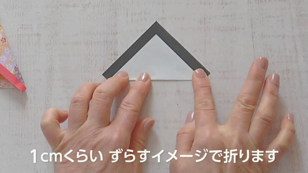 ミニサイズの黒の折り紙でお顔を作ります