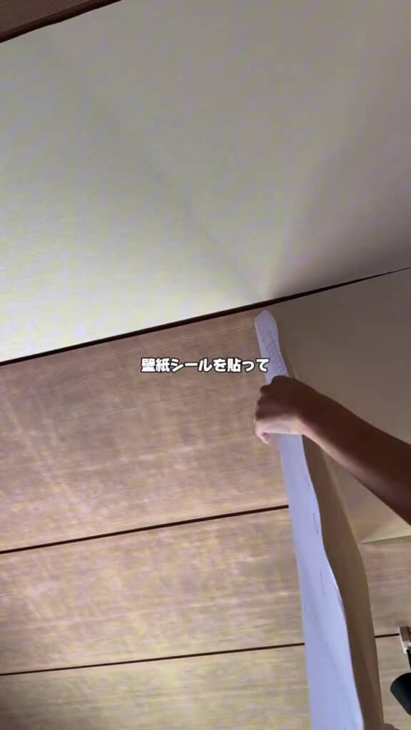 黒ずんだ天井に明るい色の壁紙シールを貼る