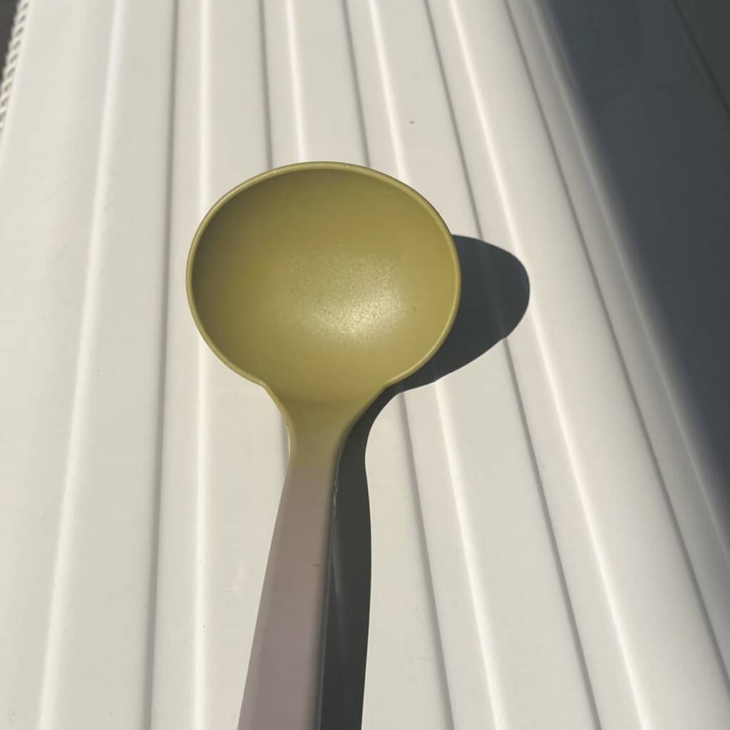 カレー由来の色素により先端が黄色くなった茶色いお玉