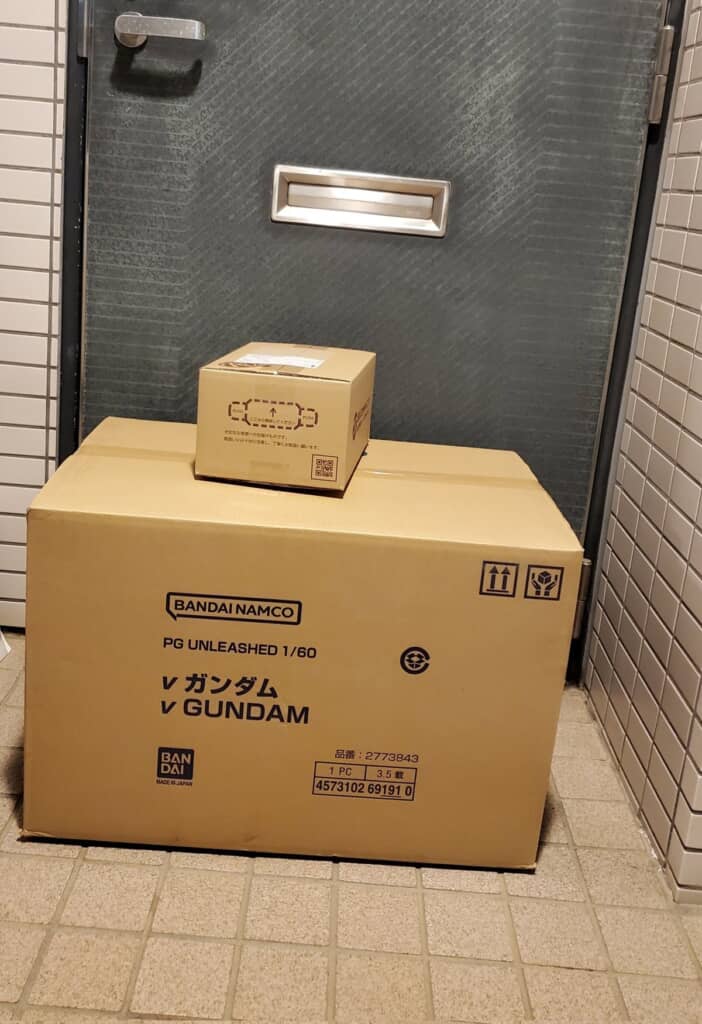 自宅玄関前に置かれた「PERFECT GRADE UNLEASHED 1/60 νガンダム」が入っている巨大な段ボール箱と専用LEDユニットが入っている段ボール箱