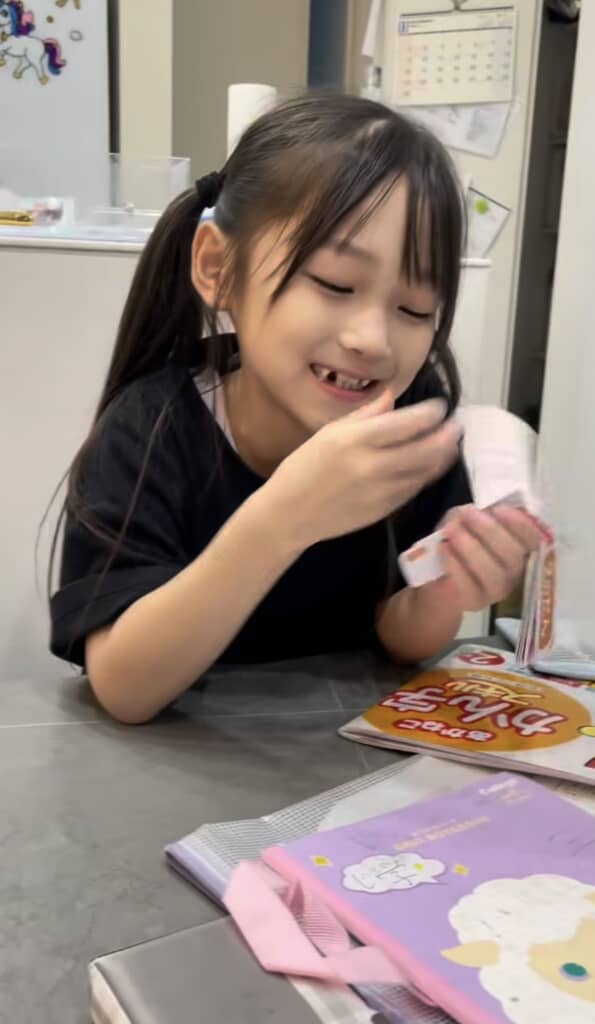 笑顔でカードをめくるツインテールの女の子