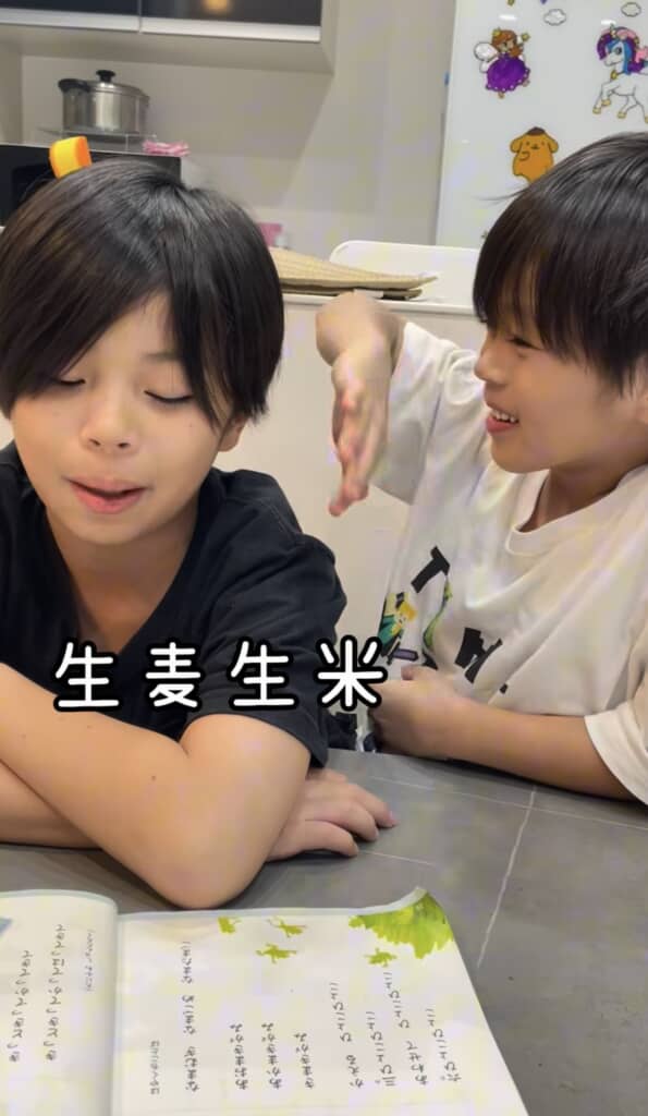 教科書を音読する男の子と横でポーズをとる男の子