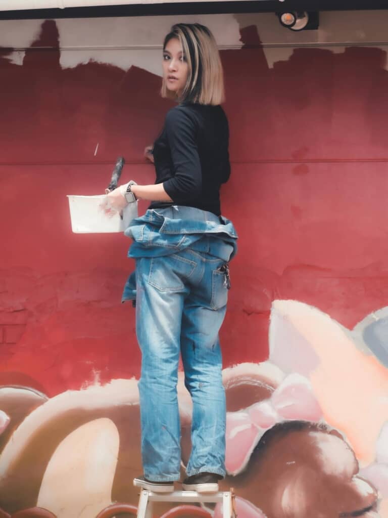 飲食店の壁面に絵を描いている投稿者