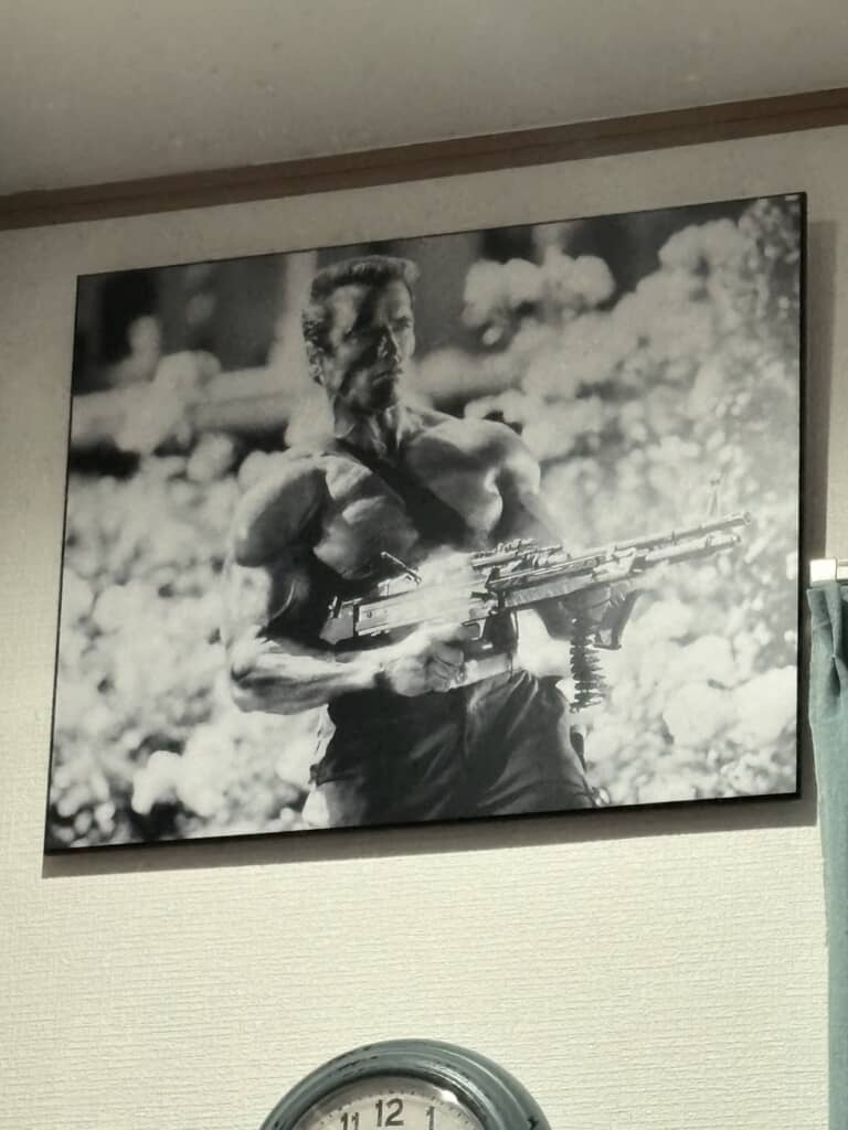 逞しい上腕二頭筋を強調してポーズをとるアーノルド・シュワルツェネッガーの額装写真