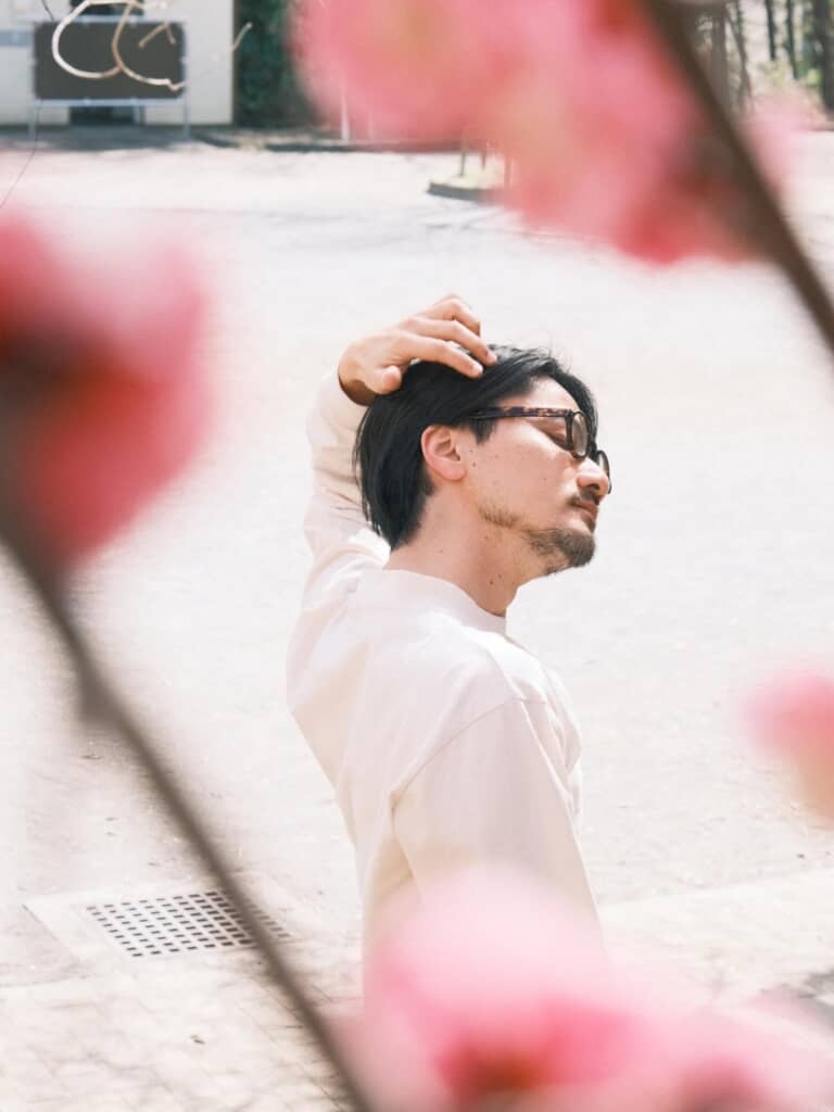 梅の花の間で髪をかき上げる佐田さん