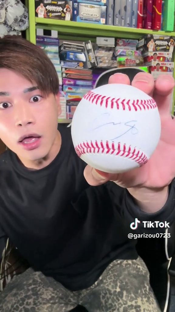 ボールに書かれているサインをカメラに向ける投稿者