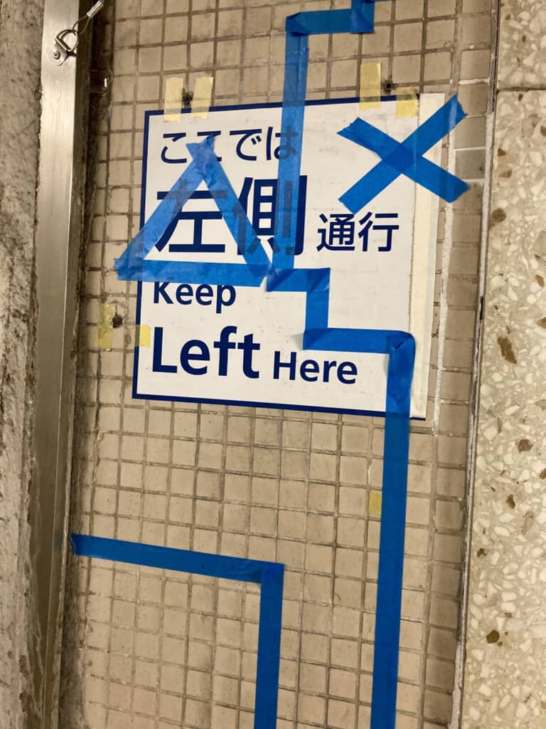 壁面に貼り付けることで形作られた青い線と三角印、×印