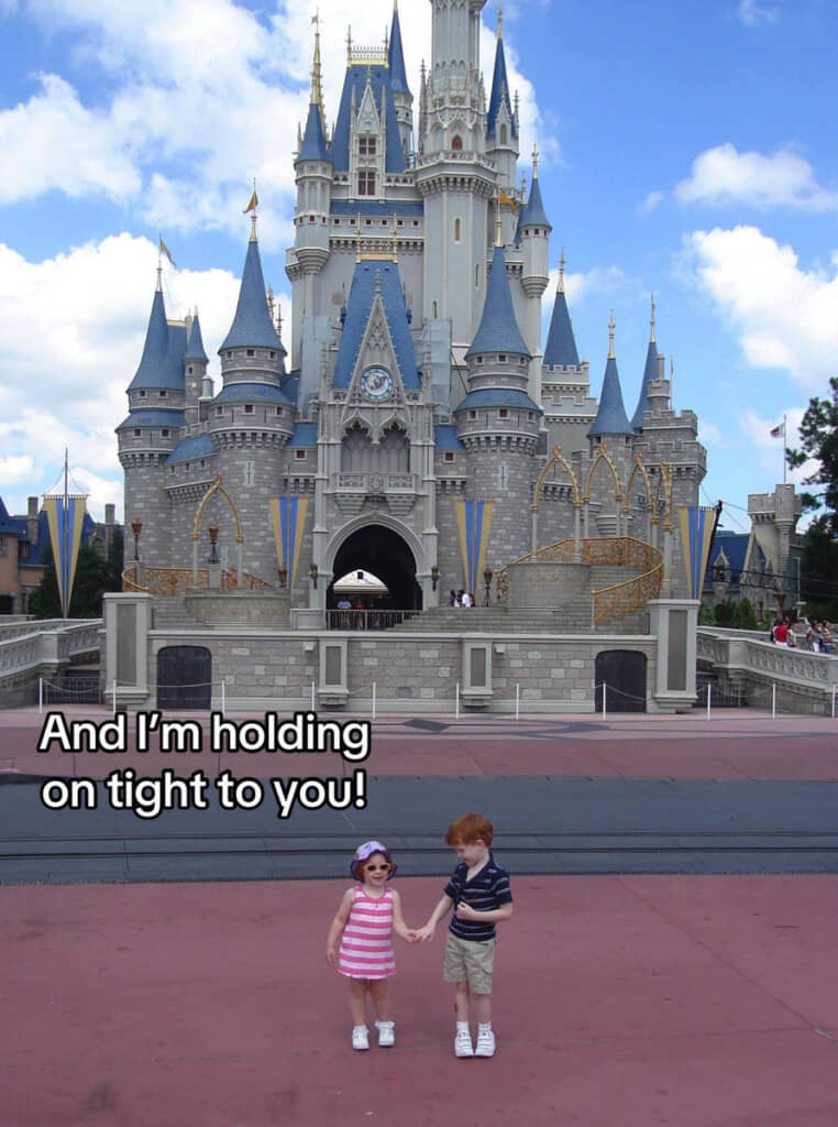 シンデレラ城の前で手を繋ぐ幼い兄と妹