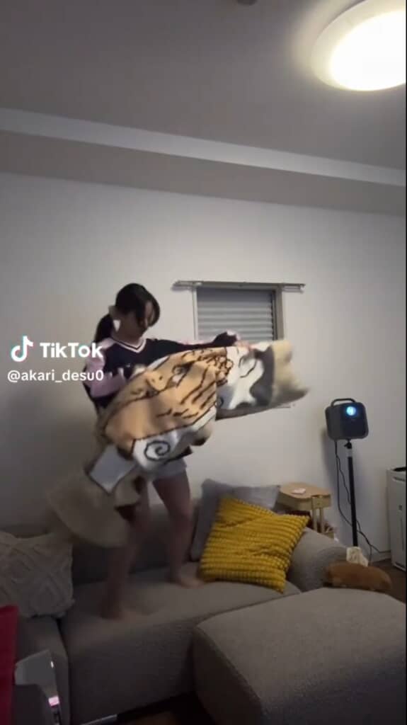 両手で作品を広げようとしている丹里さん