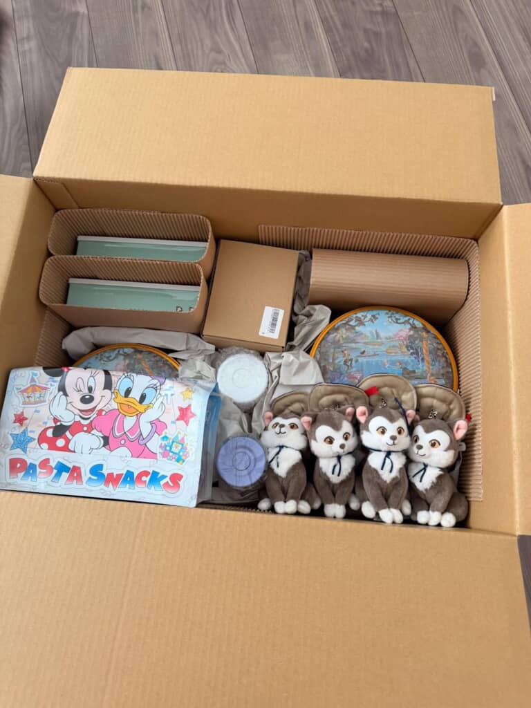段ボール箱に詰められたディズニーの菓子缶やぬいぐるみ