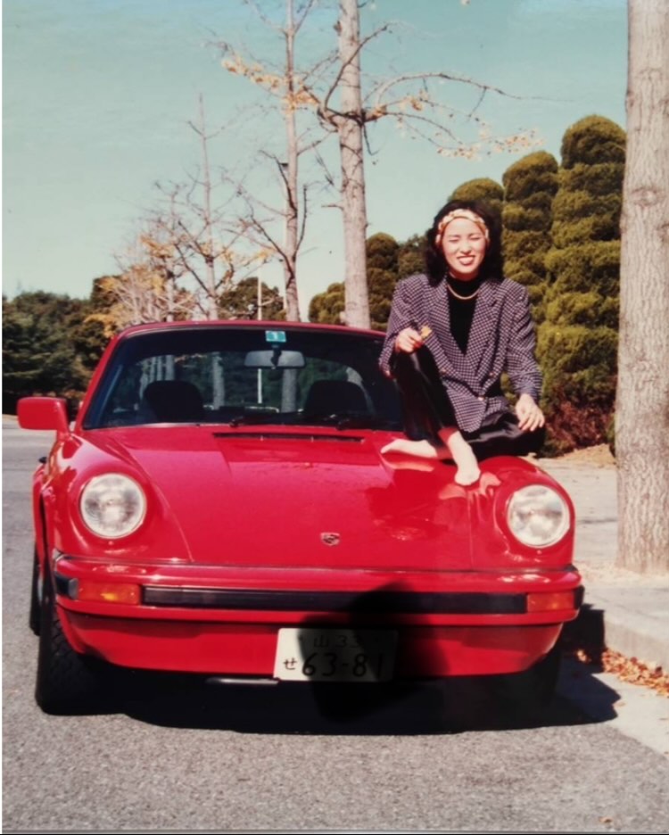 真っ赤なポルシェのボンネットに乗って胡座をかいている母