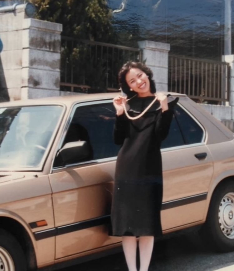 ベージュのBMWと弾けるような笑顔を見せる母