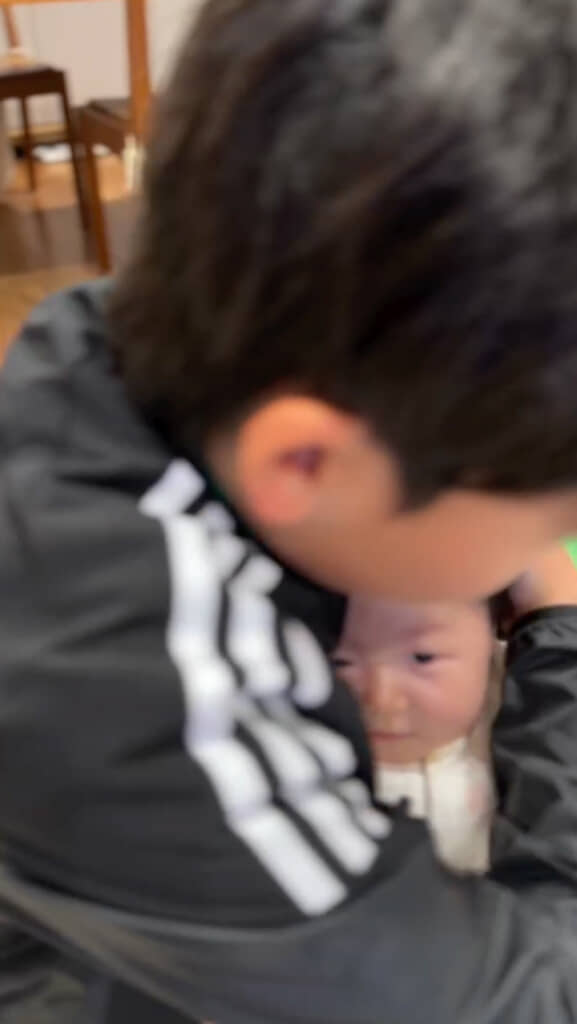 そっと頭を支える長男