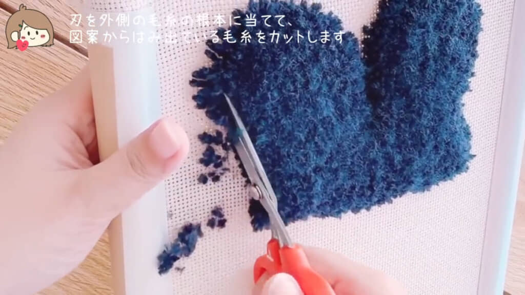刺しゅう枠(刺しゅう布)を回転させながら、はみ出ている部分をハサミで丁寧にカット