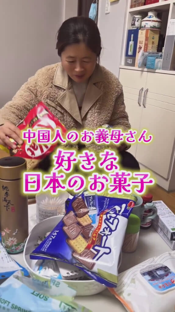 大量のお菓子を前に笑顔を見せる義母