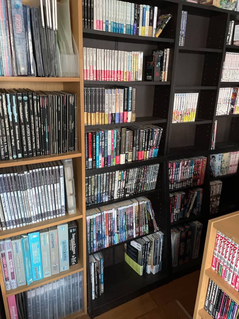 黒と木製本棚にTRPG本と漫画が整然