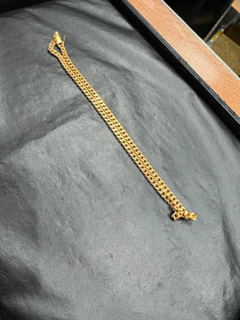 黒い布の上に置かれた金色の太チェーンブレスレット