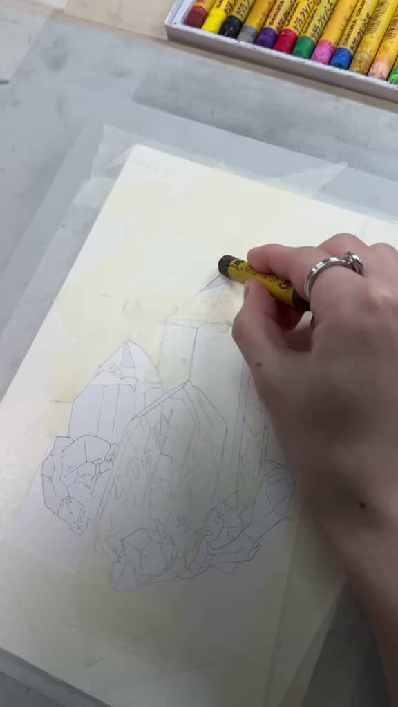 鉱石の線画にクレパスで着色する様子