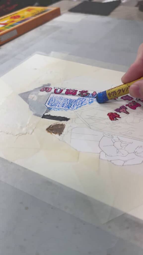 マスキングテープを貼り、一部を青く塗る様子