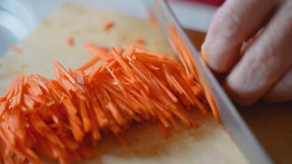手慣れた様子でニンジンを千切りに