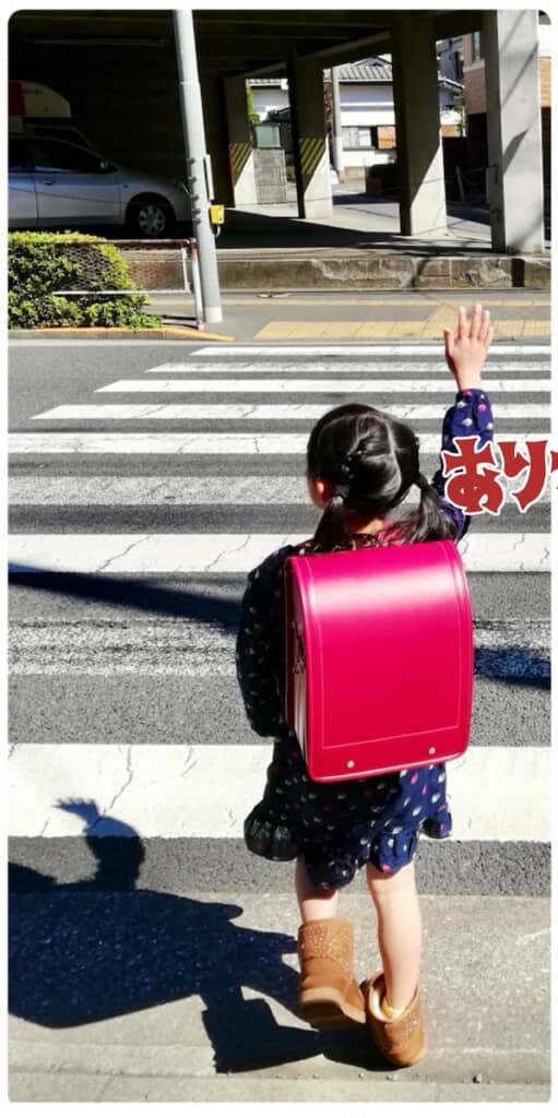 ランドセルが届いた日の娘さん。ランドセルを背負っているというより、背負われているようなサイズ感かもしれません