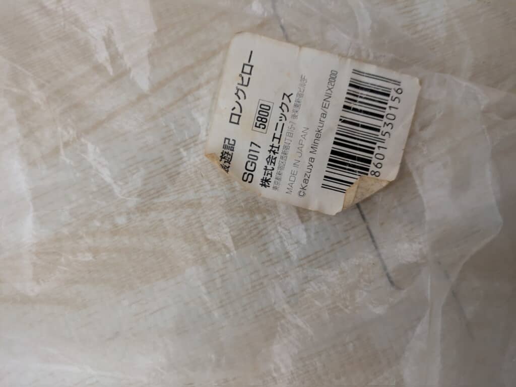 商品の詳細ラベル。「最遊記 ロングピロー」の商品名、価格（5800円）、販売元（株式会社エニックス）、2000年のコピーライトなどが記載されている。