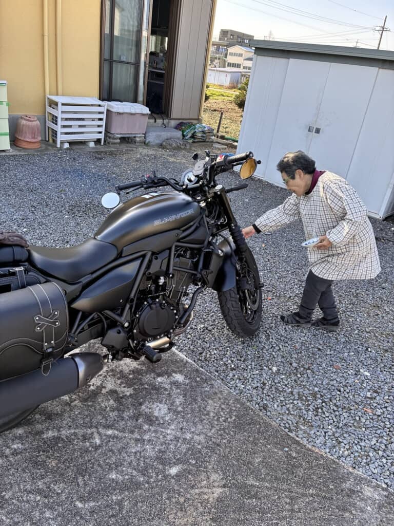 孫の無事を祈ってお清めの塩をバイクにかけている祖母