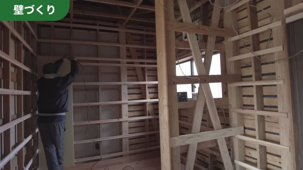 微調整した下地に石こうボードを張る様子