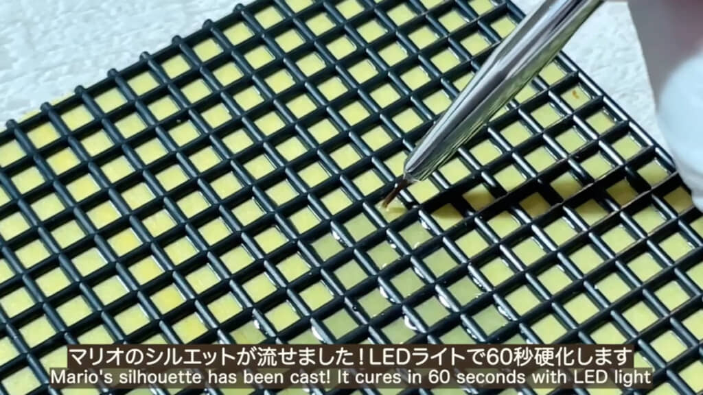 ドットを打つように鉢底ネットの“マス目”にレジンを流し入れていきます