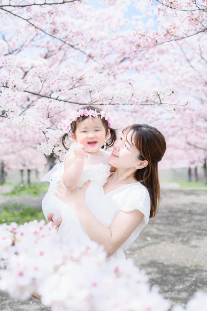 桜が舞い散る中で笑顔を見せる2人