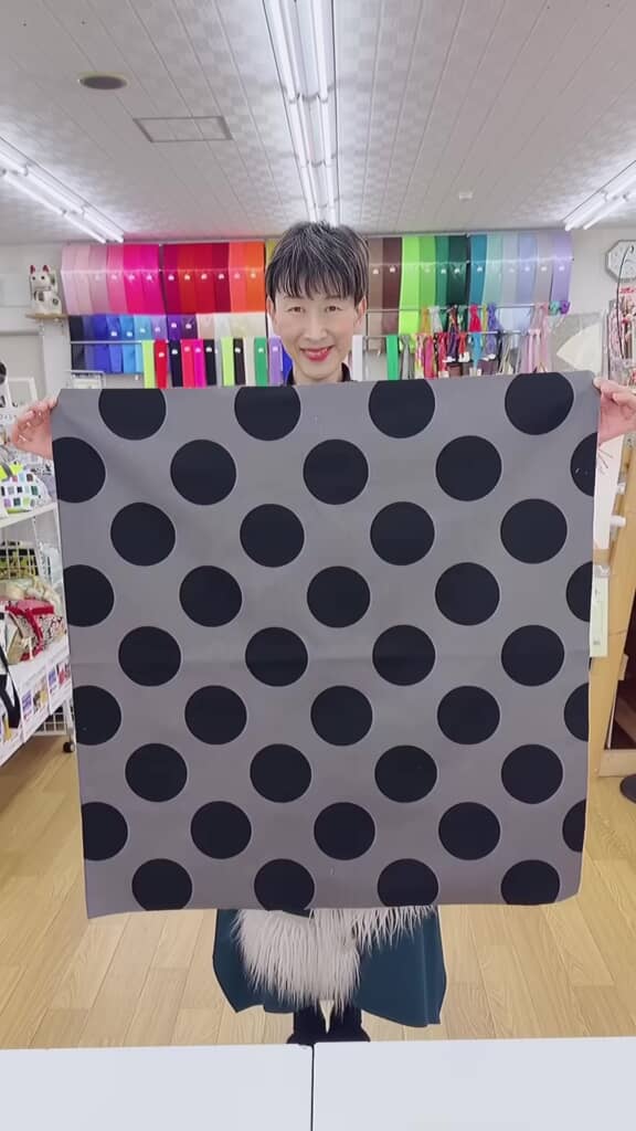 水玉色の布を広げる女性