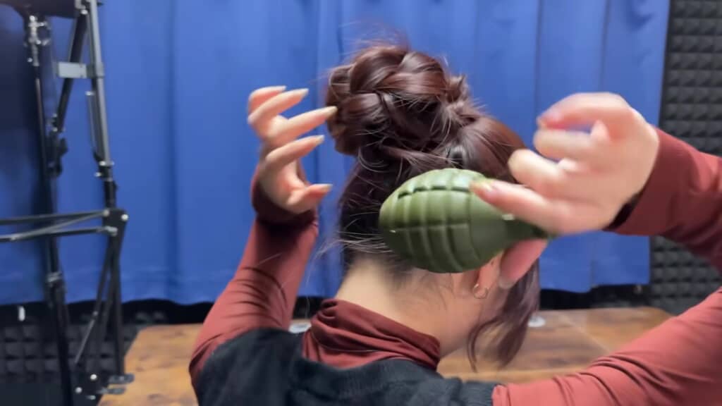 お団子ヘアから手りゅう弾を取り出すところ