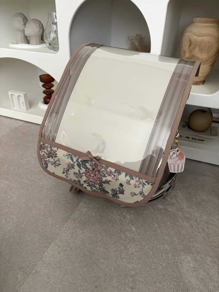 バイカラーをみせるクリアなカバーにリバティ生地の装飾がすてき