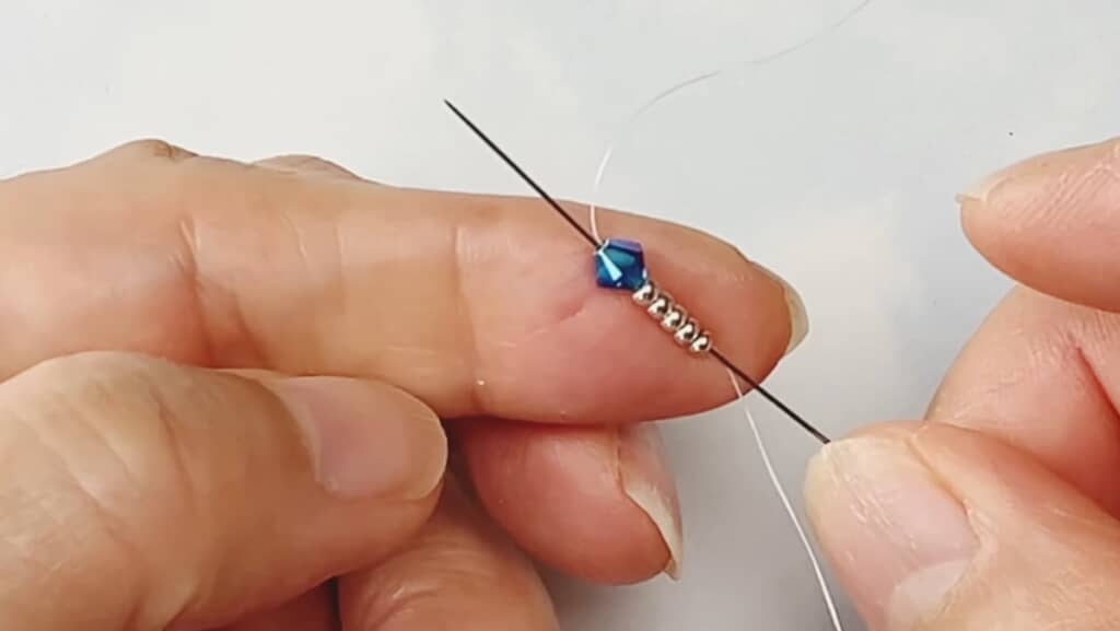 針を使ってビーズに糸を通していく