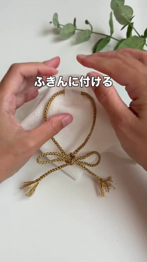 カップにかぶせたふきんに紐を付ける
