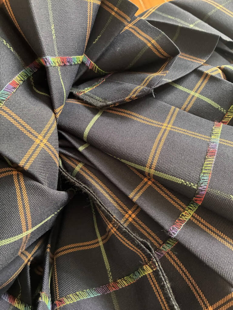 鮮やかなレインボーの糸が縫われた制服のスカートの裏側