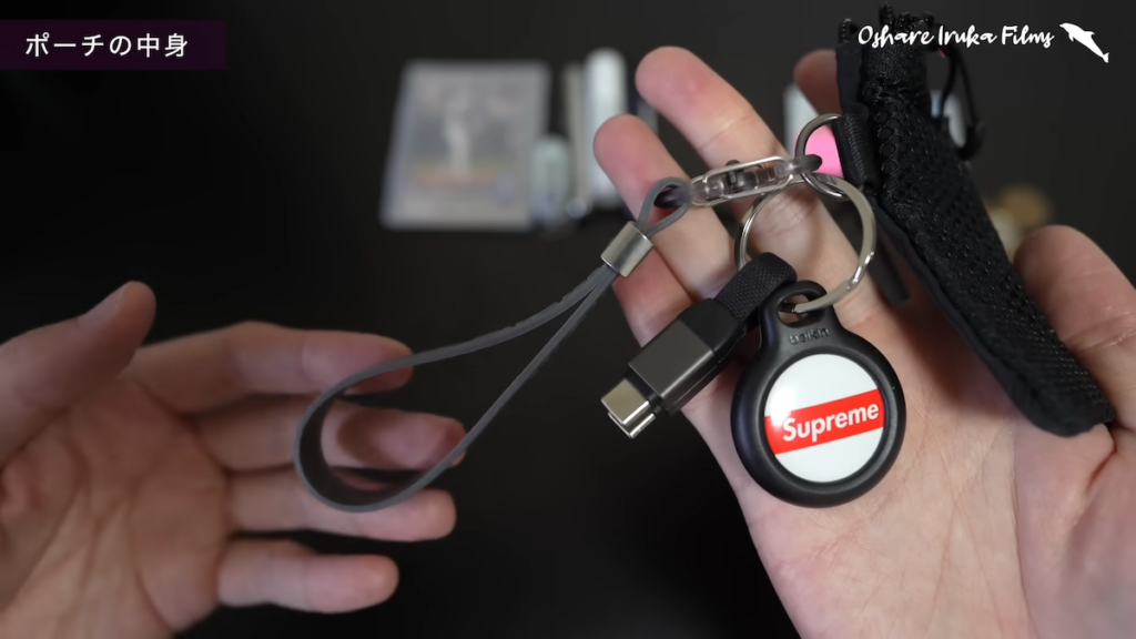 ポーチ側面の金具部分には、ストレッチストラップ、AirTag、ストラップ型ケーブルを取り付け