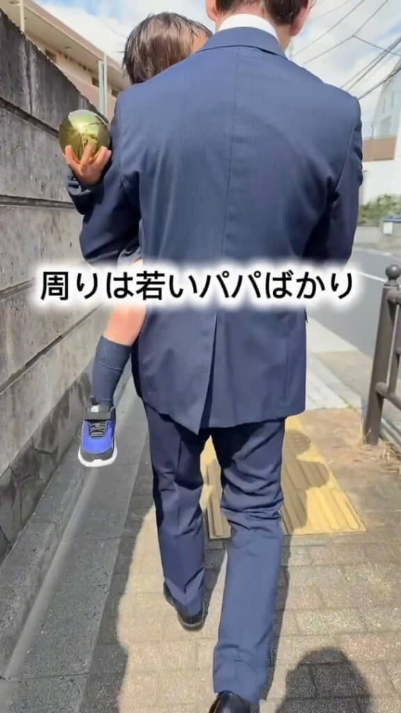 息子さんを抱っこして入園式に向かう57歳のパパさん